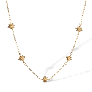 Detailed view of the gold star pendant necklace with multiple charms on a white background