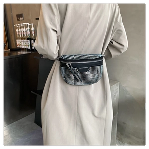 Close-up of black crossbody waist bag with silver rhinestones and elegant tassels