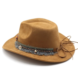 Detail of brown wide brim western hat with tassels, beads and embossed metal pendant