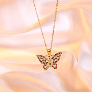 Elegant 18K gold-plated butterfly necklace with colorful crystals on champagne silk background
