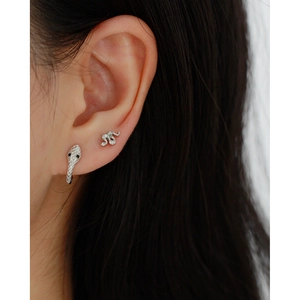 Close-up of s925 silver snake earring with black eyes and sparkling stones for ear bone