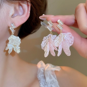 Detailed macro of zircon stud earrings featuring elegant resin flower petal tassels