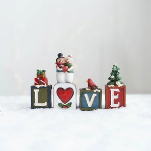 Vue détaillée des lettres LOVE de Noël en résine avec bonhomme de neige sur neige artificielle