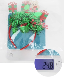 Detailed view of a plush Christmas headband on a digital scale showing 24.8g weight