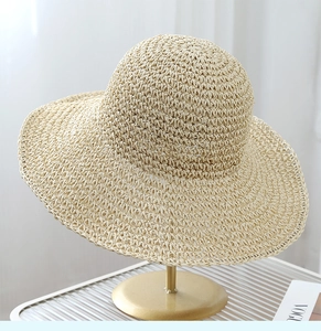 Close-up of beige woven straw hat texture on a golden display stand for sun protection