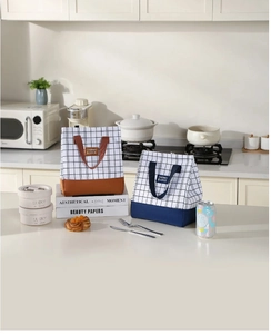 Close-up of insulated plaid lunch bags in brown and navy blue on a kitchen counter