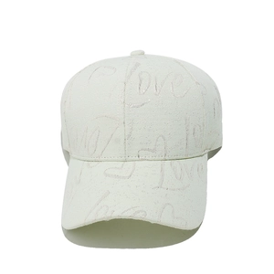 Détail d'une casquette blanche avec motif jacquard LOVE et fils métalliques
