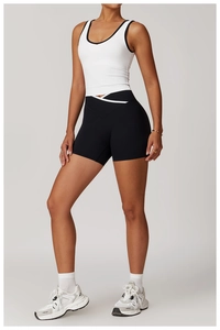 Detail of white racerback sports vest with black piping and V-shape cross waistband shorts