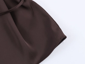Gros plan détaillé des coutures et du tissu en satin marron foncé avec finition propre