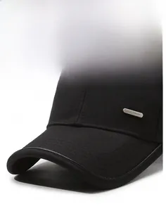 Detail of black cotton baseball cap showing reinforced brim and silver metal Fashion tag