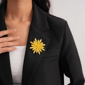 Elegant gold wheat flower brooch pinned on a black suit lapel for a luxury professional look