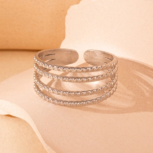 Close-up of textured multi-layer silver titanium steel open ring on beige background