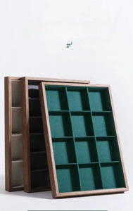 Close-up of walnut wood jewelry display trays with velvet lining in various compartments
