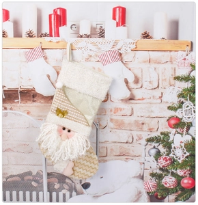 Festive Santa Christmas stocking with sequins hanging on a warm decorated fireplace mantle