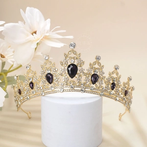 Detail of luxury baroque gold tiara with purple teardrop crystals and micro rhinestones