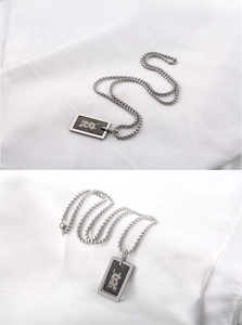 Détail du collier en acier inoxydable argenté avec un pendentif motif dragon noir