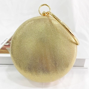Detailed view of a golden rhinestone party bag with a round metal handle and ball clasp