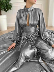 Detailed view of silver pleated dress featuring high neck, cutout chest, and long sleeves