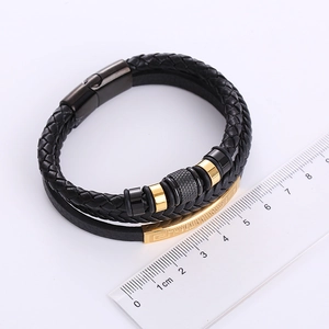 Macro detail of men's multi-layer braided leather bracelet with engraved magnetic clasp