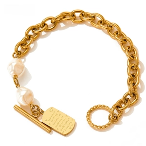 Detailed shot of baroque pearl bracelet with gold chain and OT clasp featuring engraved tag