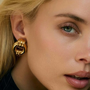 Polished 18k gold plated stainless steel nested hoop earrings worn by a model