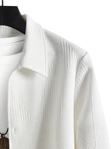 Close-up of 3D geometric embossed texture and lapel collar on white casual jacket