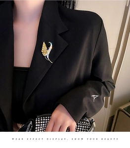 Détail de broche épi de blé dorée avec cristaux sur revers de veste noire