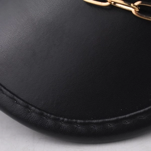 Detailed macro shot of premium black PU leather texture with gold chain on military cap