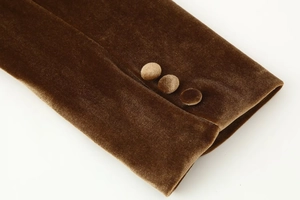 Detail of brown velvet suit sleeve featuring three matching fabric-covered buttons