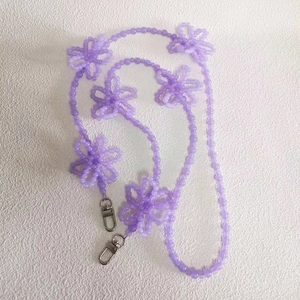 Detail of lavender beaded bag strap with handmade flower accents and metal lobster clasps