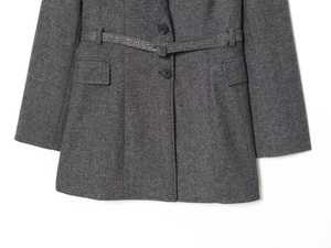 Détail d'un blazer gris foncé avec ceinture, poches à rabat et texture de laine douce