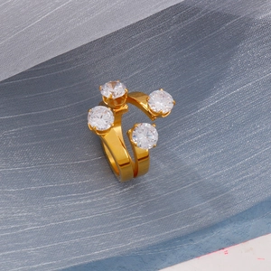 Macro detail of 18K gold-plated ring showing four offset claw-set round clear zircons