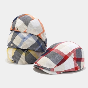 Detail view of colorful plaid newsboy caps with vintage British style and metal buckles