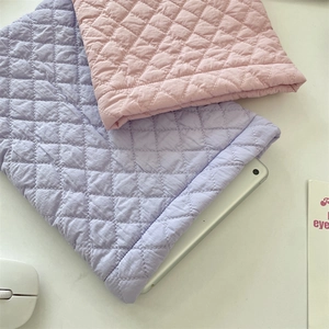 Detailed macro view of quilted diamond pattern on lavender and pink padded tablet sleeves