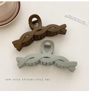Detail of matte brown and grey-blue large shark hair clips with braided texture finish