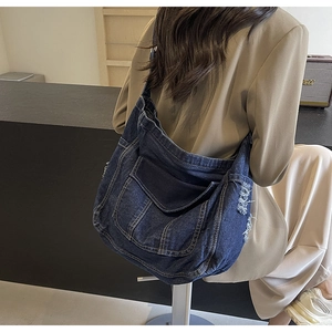 Gros plan détaillé d'un sac cabas en jean bleu avec coutures jaunes et bords effilochés