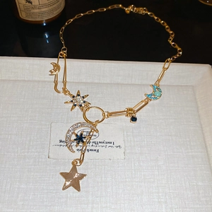 Détail du collier céleste doré avec lune en zircon, étoiles bleues et breloques émaillées