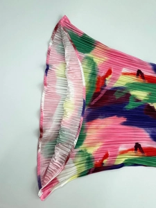 Macro shot of vertical pleated fabric with multicolor abstract art print detail