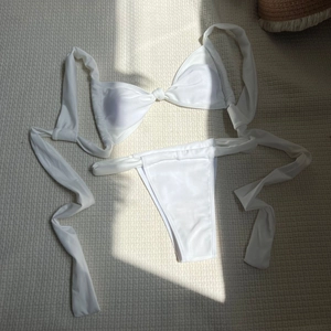 Flat lay detail of a white tie-front two-piece bikini with matte high-stretch fabric