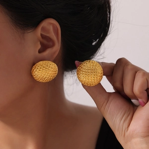 Vintage gold-plated round earrings with diamond grid pattern shown on a model