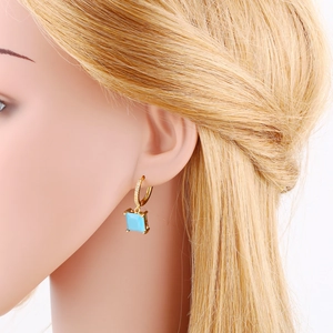 Elegant gold square blue zircon earrings with tiny diamonds shown on female model