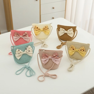 Detail view of woven straw bags in six colors with large polka dot bow decorations
