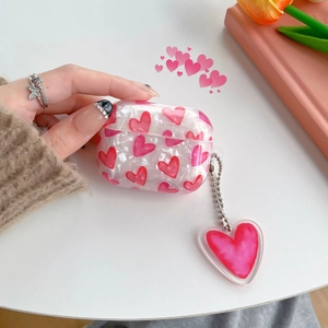 Close-up of pearl shell texture AirPods Pro case with pink hearts and metal keychain