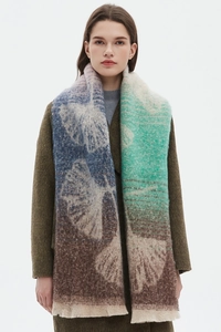 Detail of knitted jacquard scarf with abstract ginkgo leaf pattern and frayed fringes