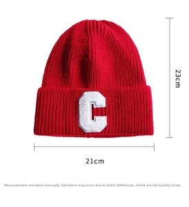 Macro view of red knit beanie with white letter C patch showing 23x21cm dimensions