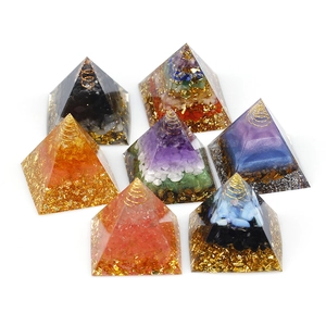 Set of seven handcrafted Orgone crystal resin pyramids in various colors on white background