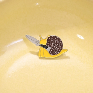 Funny cartoon snail enamel pin holding a knife, creative yellow animal alloy badge accessory