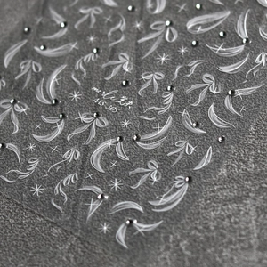 Vista macro de pegatinas 3D para uñas con lazos blancos, cintas y diamantes MS-305