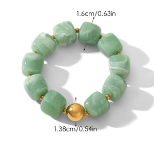 Detail view of 1.6cm green marble textured cube beads with 1.38cm gold accent bead