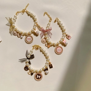 Elegant pearl pet collar with silk bow and gold pendants in black, pink and white